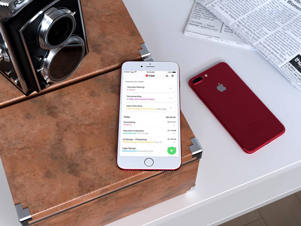 a phone laying on a table displaying the toggl track mobile iPhone application