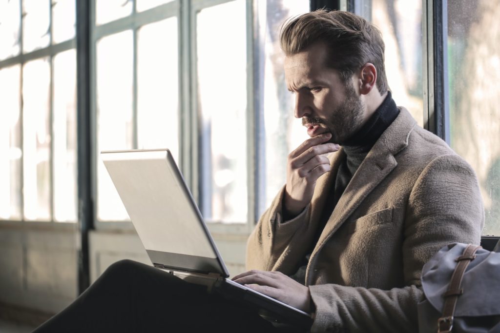 Man thinking while using laptop